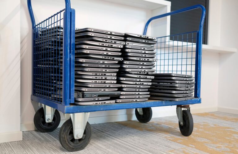 Stack of laptops on a mobile cart — ready for secure IT asset removal